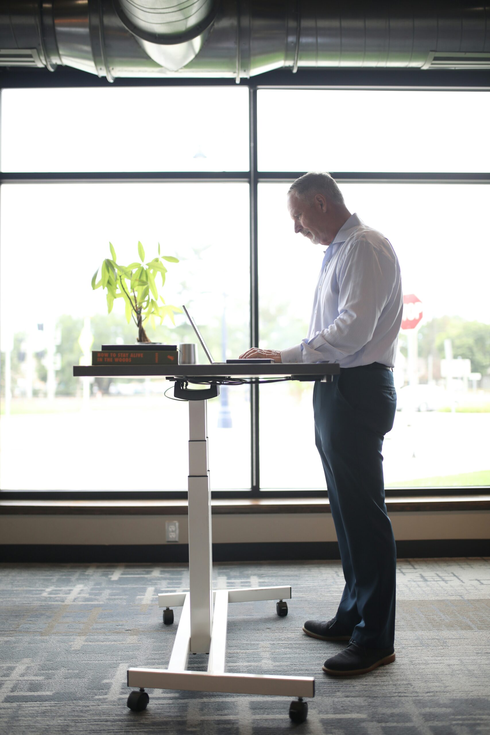 a man standing at a desk with a laptop on it